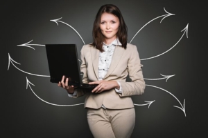 Analytics: woman in business suit holding a laptop with arrows